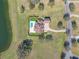Overhead aerial shot of the property, highlighting the pool, tiled roof, and manicured grounds by a tranquil lake at 12329 Sw 140Th Loop, Dunnellon, FL 34432