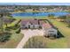 Beautiful aerial view of the home, featuring a long driveway, lush lawns, mature trees, and a lake view at 12329 Sw 140Th Loop, Dunnellon, FL 34432