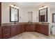 Double vanity bathroom featuring granite countertops, wood cabinetry and framed mirrors at 12329 Sw 140Th Loop, Dunnellon, FL 34432