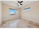 Bright bedroom with ceiling fan, neutral walls and a large window overlooking the backyard at 12329 Sw 140Th Loop, Dunnellon, FL 34432
