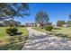 Beautiful home featuring a circular driveway and lush green lawn and mature trees at 12329 Sw 140Th Loop, Dunnellon, FL 34432