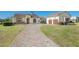 Charming front exterior with a brick-paved driveway and a well-manicured lawn and lush landscaping at 12329 Sw 140Th Loop, Dunnellon, FL 34432