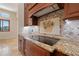 Close-up of the kitchen cooktop with custom backsplash, granite counters, and wood cabinets at 12329 Sw 140Th Loop, Dunnellon, FL 34432