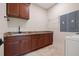 Laundry room with granite countertop, wood cabinets and a stainless steel sink at 12329 Sw 140Th Loop, Dunnellon, FL 34432