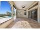 The covered patio features travertine floors, recessed lights, ceiling fan, and views of the pool at 12329 Sw 140Th Loop, Dunnellon, FL 34432