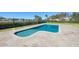 A luxurious backyard features a modern pool, patio and lush green landscaping, perfect for relaxation at 12329 Sw 140Th Loop, Dunnellon, FL 34432