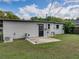 Spacious backyard with a small concrete patio, exterior door, well-maintained lawn, and partial fencing at 2625 Williston Dr, Lakeland, FL 33801