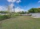 Expansive backyard with lush green grass, bordered by a wooden fence for privacy and a view of the blue sky at 2625 Williston Dr, Lakeland, FL 33801