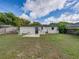 Large backyard with a compact concrete patio, lush lawn, and secure fencing, perfect for outdoor activities at 2625 Williston Dr, Lakeland, FL 33801