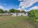 Green backyard featuring a small patio, mature landscaping, and secure fencing for privacy and enjoyment at 2625 Williston Dr, Lakeland, FL 33801