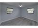 Charming bedroom featuring wood-look floors, a modern ceiling fan, and natural light from two windows at 2625 Williston Dr, Lakeland, FL 33801