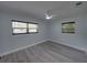 Bright bedroom with two windows, modern ceiling fan, light blue walls and light gray flooring at 2625 Williston Dr, Lakeland, FL 33801