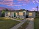 Charming home featuring a green front door, well-maintained lawn, and a driveway, captured at dusk at 2625 Williston Dr, Lakeland, FL 33801