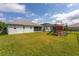 Large, grassy backyard includes a playset and backs up to another property at 30505 Island Club Dr., Deer Island, FL 32778