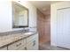 Updated bathroom features a granite countertop, neutral paint, and tiled walk-in shower at 30505 Island Club Dr., Deer Island, FL 32778