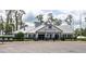 Exterior view of the Deer Island Golf clubhouse, featuring a white facade, black shutters, and golf carts at 30505 Island Club Dr., Deer Island, FL 32778