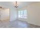 Bright dining room featuring neutral walls, tile flooring, large window, and chandelier at 30505 Island Club Dr., Deer Island, FL 32778
