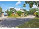 Community entrance with manicured landscaping, brick pillars, palm trees, and a picturesque view at 30505 Island Club Dr., Deer Island, FL 32778