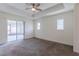 Spacious main bedroom with ceiling fan, tray ceiling, and access to outdoor space at 30505 Island Club Dr., Deer Island, FL 32778