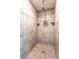 The walk-in shower features neutral tile, built-in corner shelves and a rainfall shower head at 30505 Island Club Dr., Deer Island, FL 32778