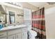 Well-lit bathroom features a single sink vanity, mirror, and a shower with colorful patterned curtain at 4889 Myrtle View N Dr, Mulberry, FL 33860
