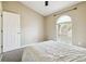Bright bedroom featuring a vaulted ceiling, arched window with blinds, and neutral decor at 4889 Myrtle View N Dr, Mulberry, FL 33860