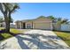 Charming single-Gathering home featuring a two-car garage and lush front lawn on a sunny day at 4889 Myrtle View N Dr, Mulberry, FL 33860