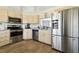 Modern kitchen features stainless steel appliances, light wood cabinetry, and wood-look flooring at 4889 Myrtle View N Dr, Mulberry, FL 33860