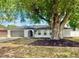 Charming home featuring a huge shade tree, manicured landscaping, and a two-car garage at 66 Alachua Dr, Winter Haven, FL 33884