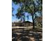 Cozy home with neutral tones, inviting front yard shaded by mature trees, evoking a sense of country charm at 8955 Rhoden Loop W Rd, Fort Meade, FL 33841