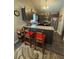 Cozy kitchen featuring dark cabinets, granite countertops, stainless steel appliances, and seating for two at 8955 Rhoden Loop W Rd, Fort Meade, FL 33841