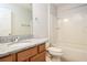 Bathroom features granite counters, vanity, mirror, bathtub with shower, tile floor, and toilet at 2573 Carrington Ct, The Villages, FL 32162
