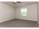 Neutral-toned bedroom with carpeting, a ceiling fan, and a large window offering natural light at 2573 Carrington Ct, The Villages, FL 32162