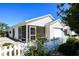A cozy home with a screened-in lanai and a white picket fence surrounding the well-maintained landscaping at 2573 Carrington Ct, The Villages, FL 32162