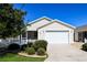 Charming single-story home featuring a well-manicured lawn, white picket fence and an attached two-car garage at 2573 Carrington Ct, The Villages, FL 32162