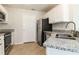 Well-lit kitchen featuring stainless steel appliances, granite countertops, and ample cabinet space at 2573 Carrington Ct, The Villages, FL 32162
