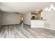 Open-concept living space with neutral walls, grey wood-look flooring, ceiling fan and kitchen bar at 2573 Carrington Ct, The Villages, FL 32162