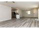 Spacious, freshly painted living room with grey laminate floors, stainless steel appliances, and natural light at 2573 Carrington Ct, The Villages, FL 32162