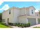 A side view of a two-story townhome with manicured landscaping at 591 Bay Leaf Dr, Poinciana, FL 34759