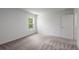 A bright bedroom featuring neutral carpet, a window with a view, and fresh, white walls at 607 Bay Leaf Dr, Poinciana, FL 34759