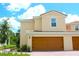 Charming two-story home featuring a terracotta roof, warm exterior paint, and a two-car garage at 607 Bay Leaf Dr, Poinciana, FL 34759