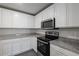 Close-up of kitchen featuring white cabinets, granite countertops, and stainless steel appliances at 607 Bay Leaf Dr, Poinciana, FL 34759