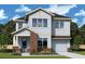 New construction of a charming two-story home with a brick-accented entryway and an attached two car garage at 1205 Eastin Ave, Orlando, FL 32804