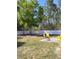 A partial view of a fenced in back yard with a concrete patio and outdoor furniture at 13378 Sw 89Th Ter, Ocala, FL 34473