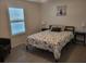 Bedroom with neutral walls, decorative art, and a window with plantation shutters at 13378 Sw 89Th Ter, Ocala, FL 34473