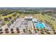 Aerial view of community amenities featuring a pool, parking, green spaces, and school at 329 W Aster Ct, Poinciana, FL 34759