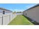 Backyard featuring lush green grass and a white vinyl fence providing privacy at 329 W Aster Ct, Poinciana, FL 34759