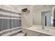Bright bathroom featuring a single sink vanity and a shower with a stylish striped curtain at 329 W Aster Ct, Poinciana, FL 34759