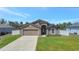 Inviting single-Gathering home featuring an attached garage, concrete driveway, and manicured front lawn at 329 W Aster Ct, Poinciana, FL 34759