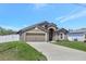 Charming one-story home with a two-car garage and well-manicured lawn, nestled in a tranquil neighborhood setting at 329 W Aster Ct, Poinciana, FL 34759